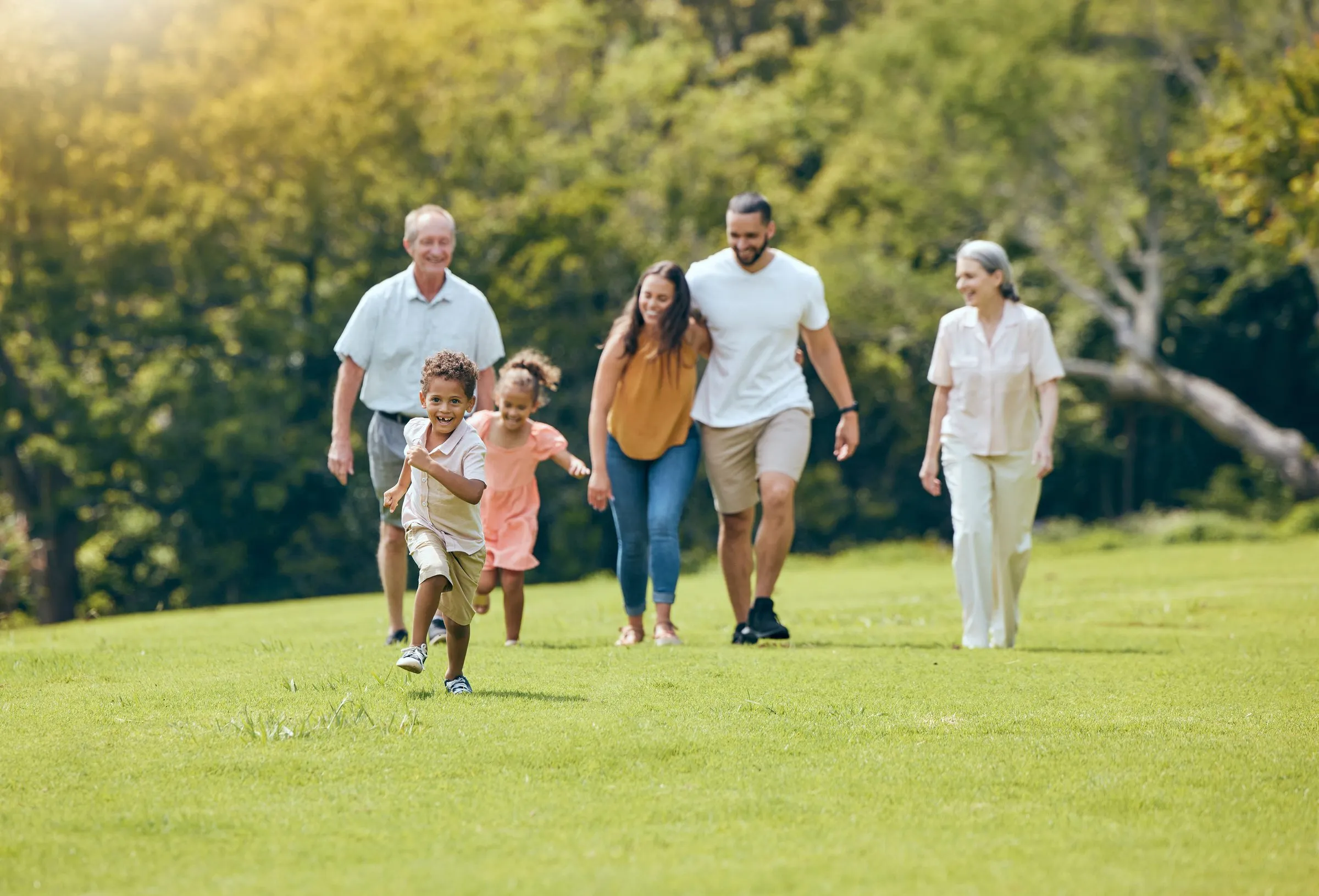 A family walks across a sunny park