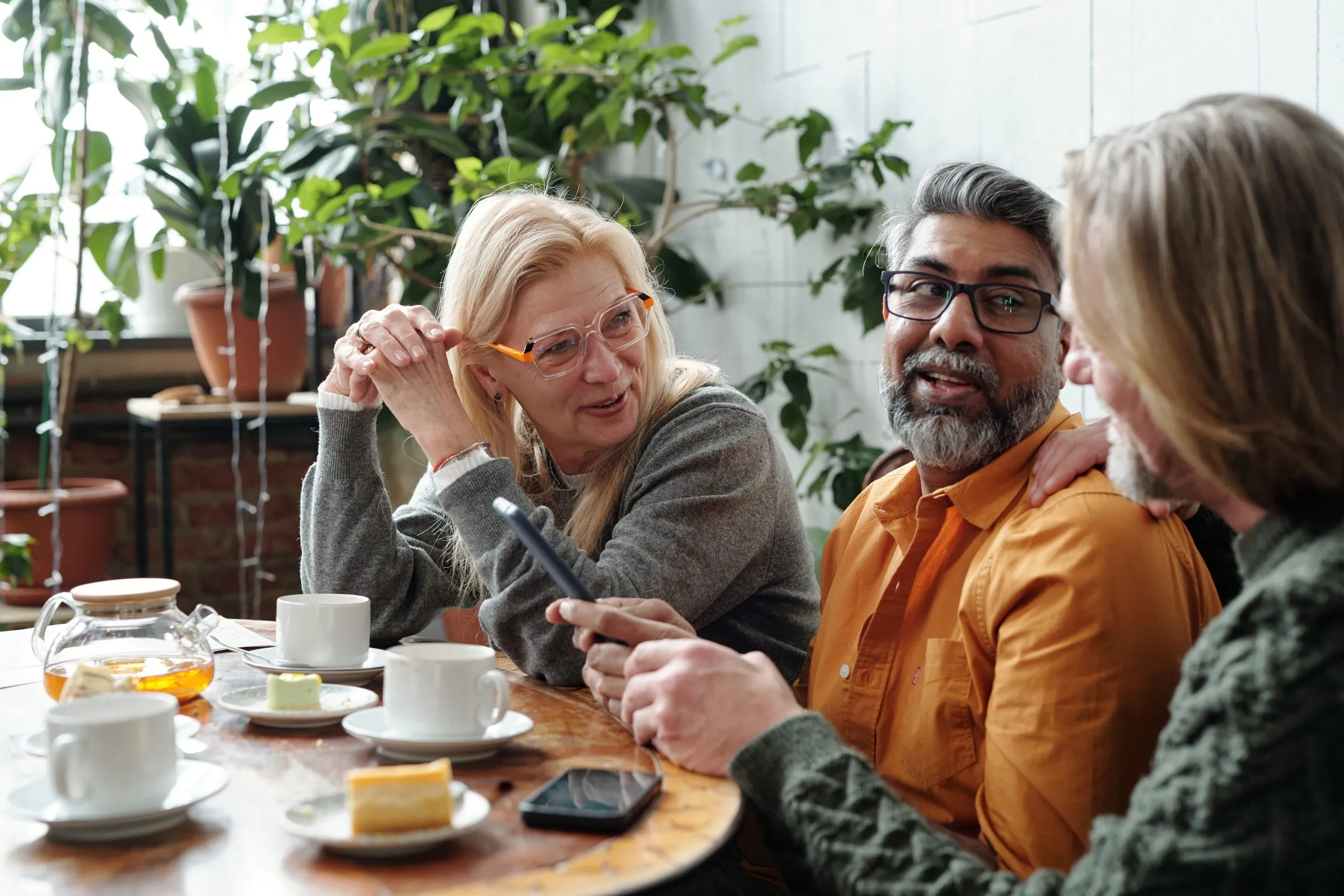 Friends talk over coffee and cake in a café