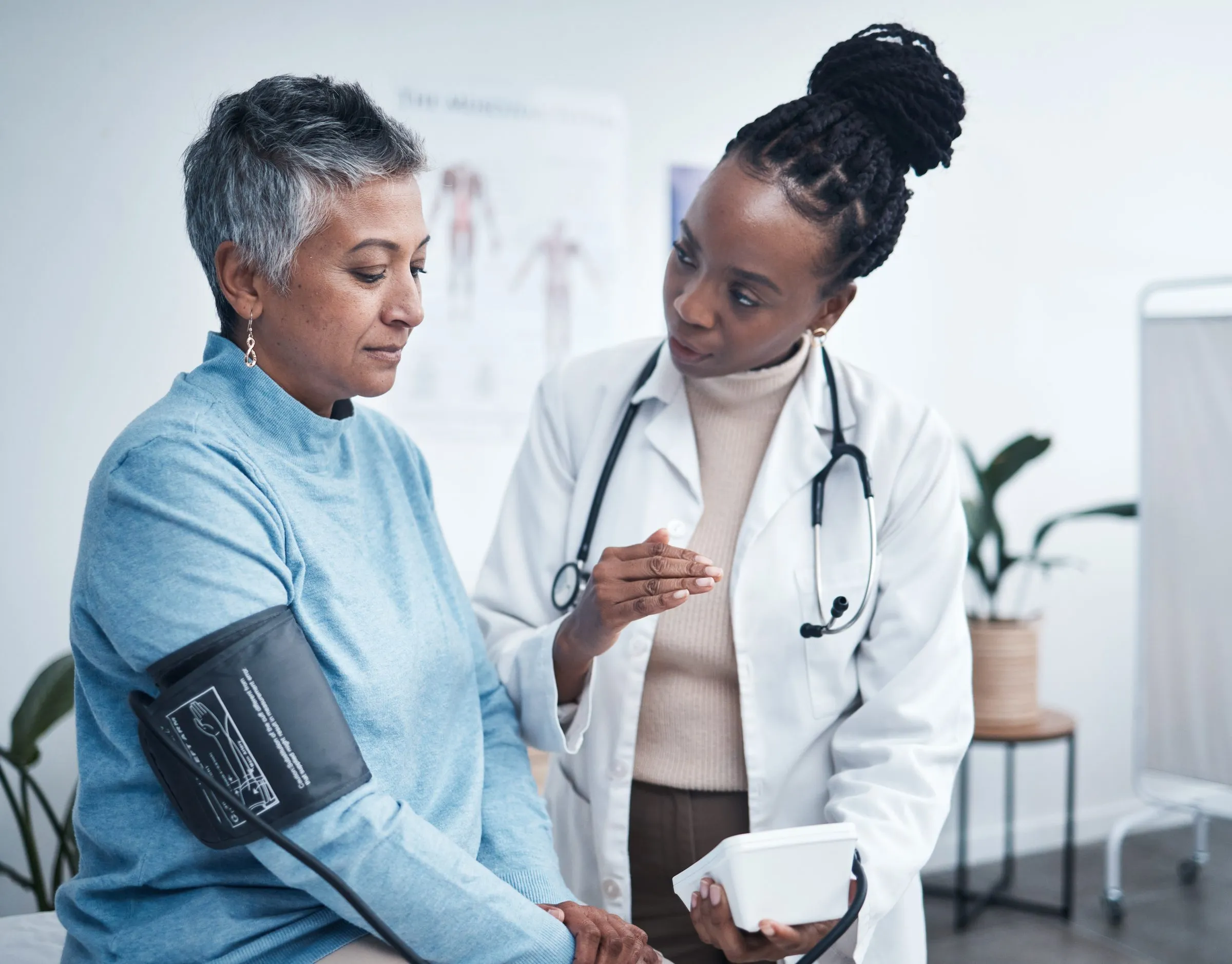 A doctor talks with a woman during a blood pressure check