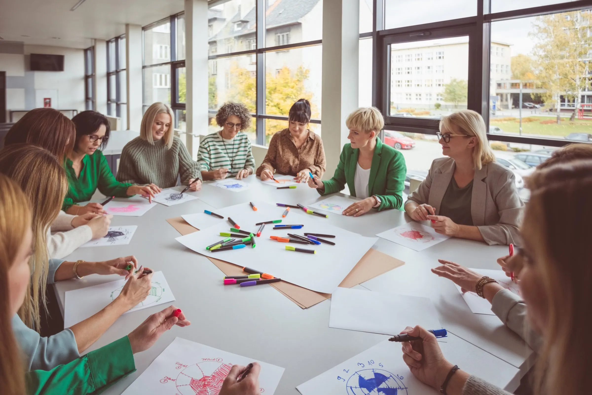 A group sketches ideas with coloured pens around a large table