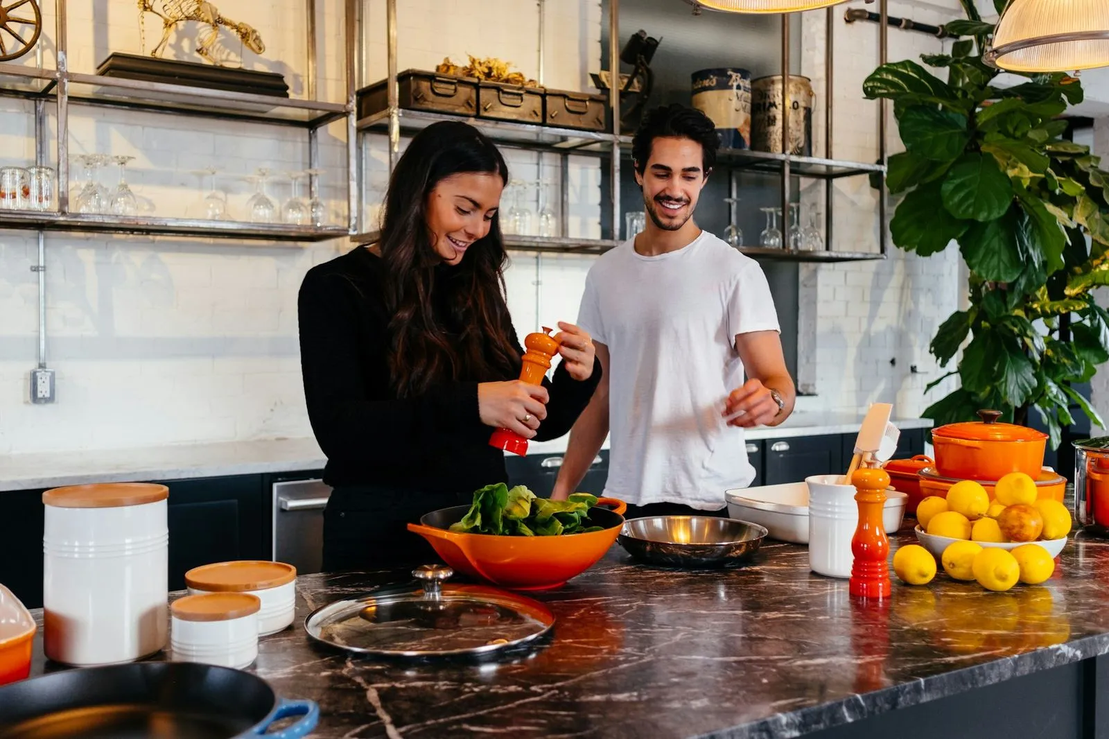 A couple cook a healthy meal together in their kitchen