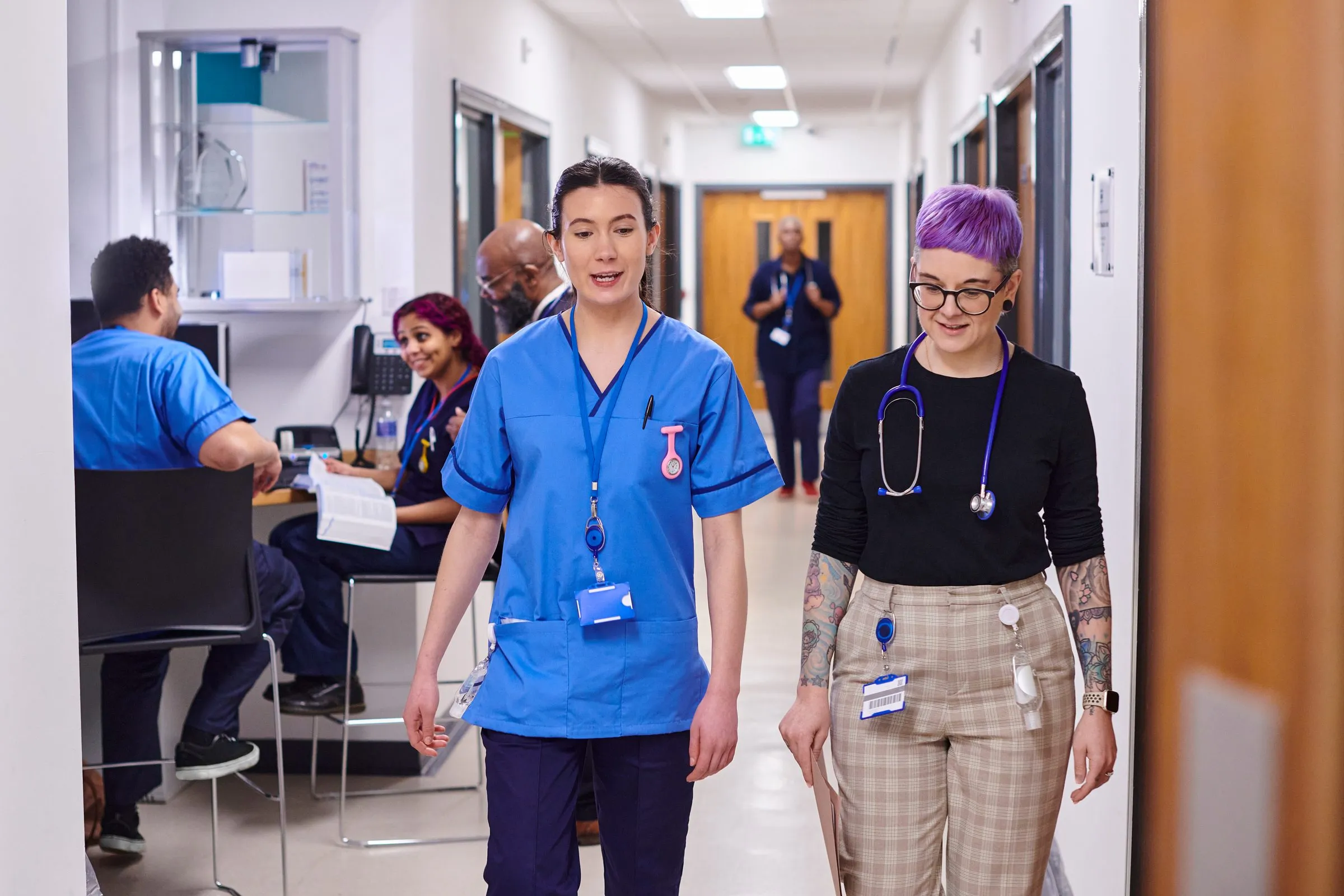 Nurses walk past the nurses’ station on a hospital ward