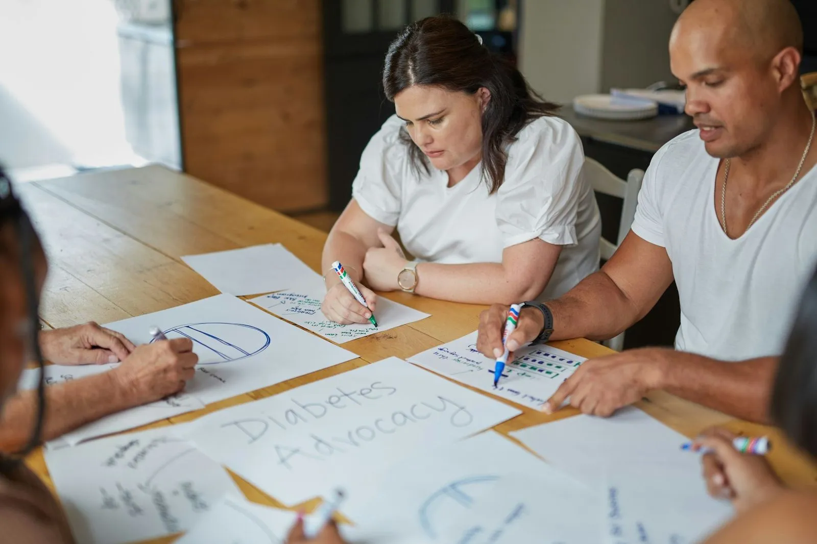 People work through diabetes education materials around a table