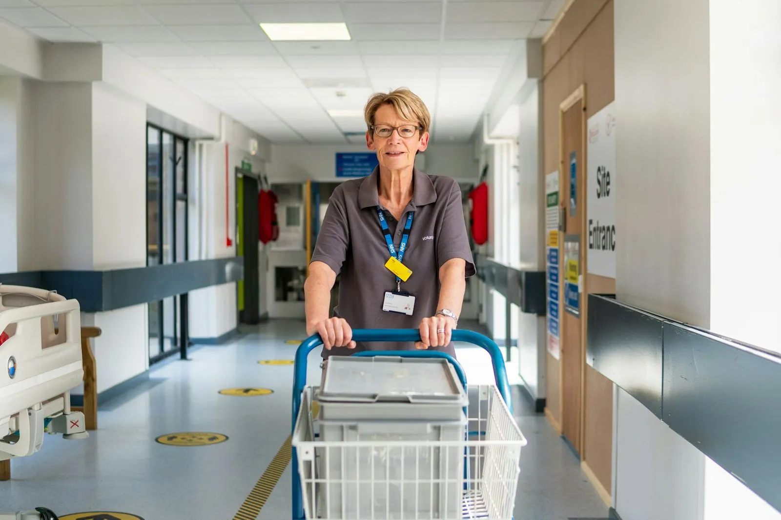 A nurse walks along a hospital corridor