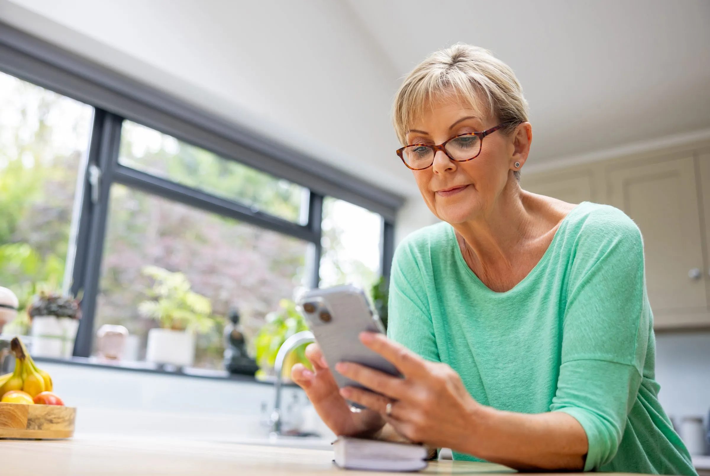 An older woman uses a health app on her phone at home