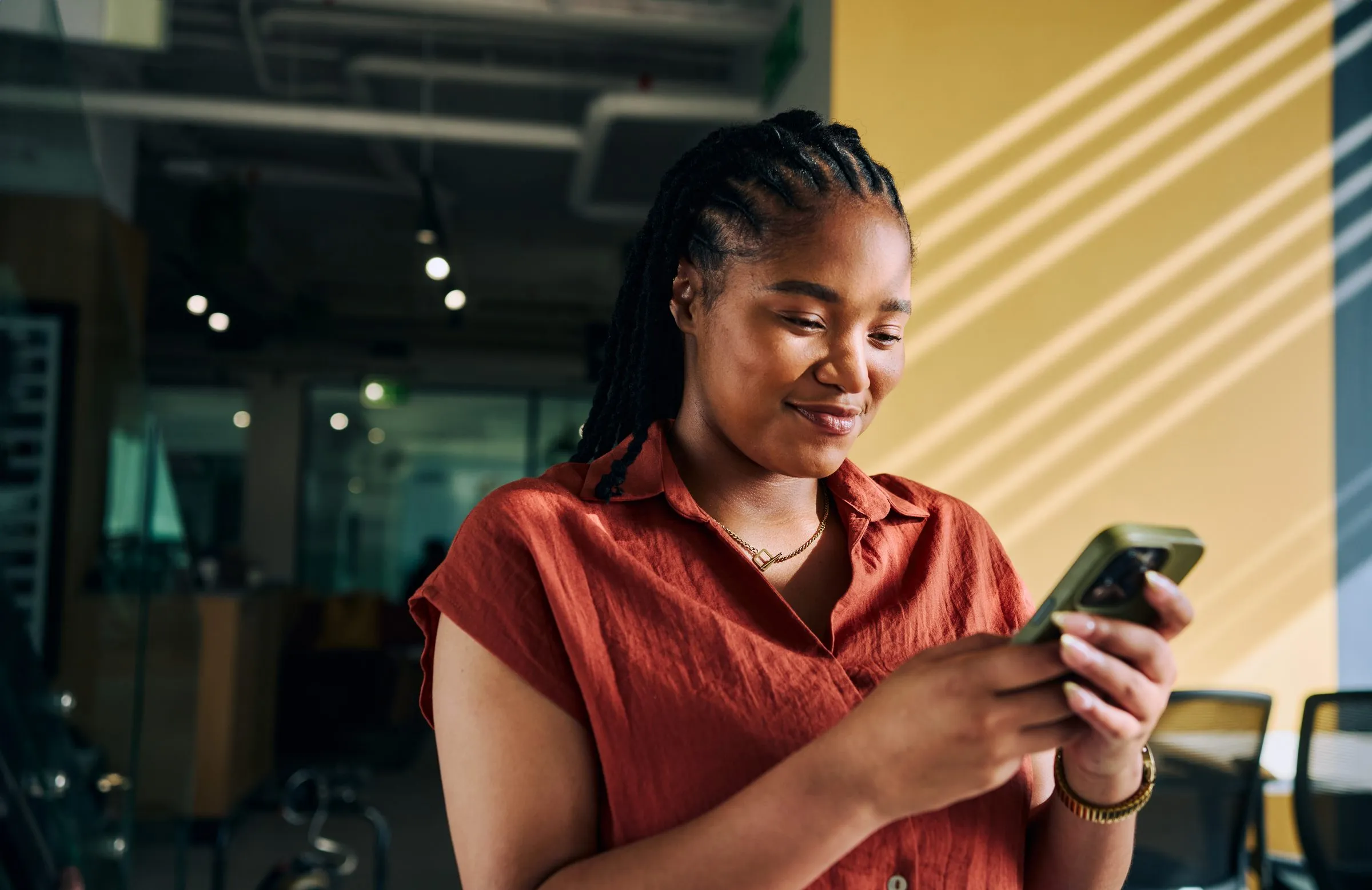 A smiling woman looks at her phone